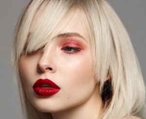 Woman with a platinum blonde bob and a sideswept fringe